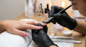 Nail technician filling the grown-out area of a client’s acrylic nails.