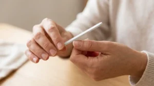 Woman keeping damaged nails after gel polish short and softly shaped with a nail file.