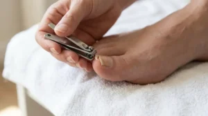 Person checking whether the loose edge of a big toenail can be safely trimmed.