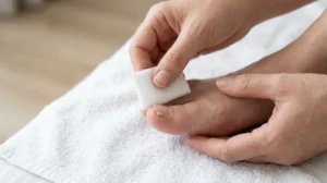Person covering a loose big toenail with a sterile nonstick dressing.
