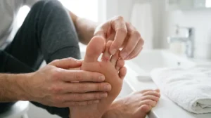 Person locating a small cut under the toe with clean hands.