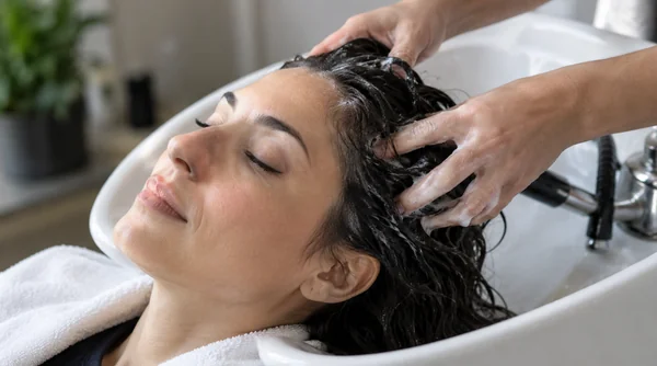 Gently working shampoo through the scalp with fingertips.