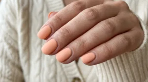 Close-up of soft matte peach nails with a smooth velvety finish