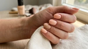 Close-up of a manicure featuring five soft mixed peach tones