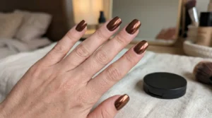 Close-up of copper-brown chrome nails with warm reflective highlights