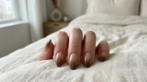 Close-up of brown chrome ombré nails fading from nude to chocolate brown
