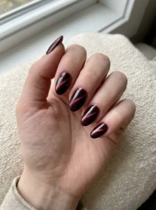 Realistic burgundy cat-eye nails in a consistent soft almond shape