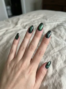 Five charcoal cat-eye nails showing different natural magnetic shimmer patterns