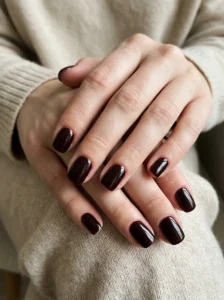 Classic glossy black cherry nails on natural-looking hands