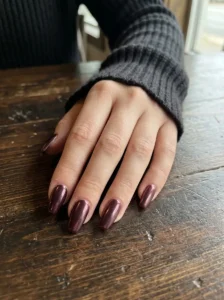 Glossy black cherry chrome nails with a metallic finish
