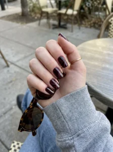 Black cherry swirl nails with delicate burgundy nail art