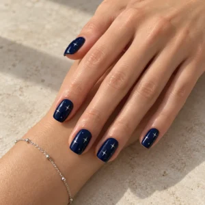 Midnight blue nails with tiny silver stars and a delicate silver bracelet.