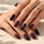 Summer witchy nails in glossy black and deep plum with silver moon and star accents. 10