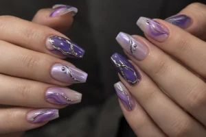 Close-up of purple coffin nails with lilac swirls, sculpted silver outlines, and tiny silver beads.