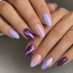 Purple nails almond manicure featuring lilac polish, French tips, violet cat eye shimmer, and a white flower accent