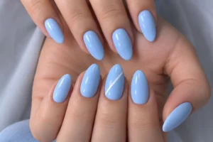 Close-up of glossy soft blue almond nails with one fine diagonal white stripe on an accent nail.