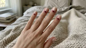 Burgundy reverse French manicure with curved accents along the cuticles