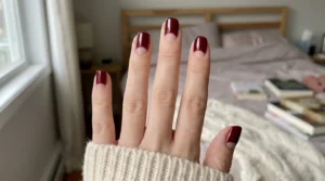 Burgundy and nude half-moon manicure on short rounded nails